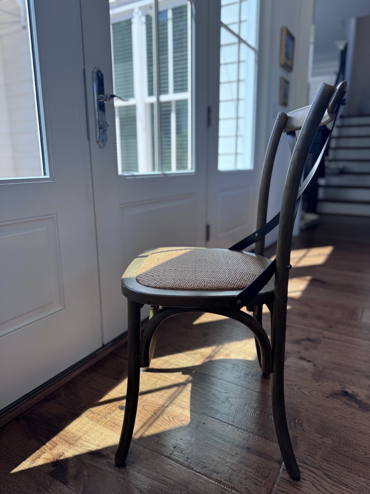 Empty wooden chair facing a door with natural light, symbolizing absence and the conversation that should be happening