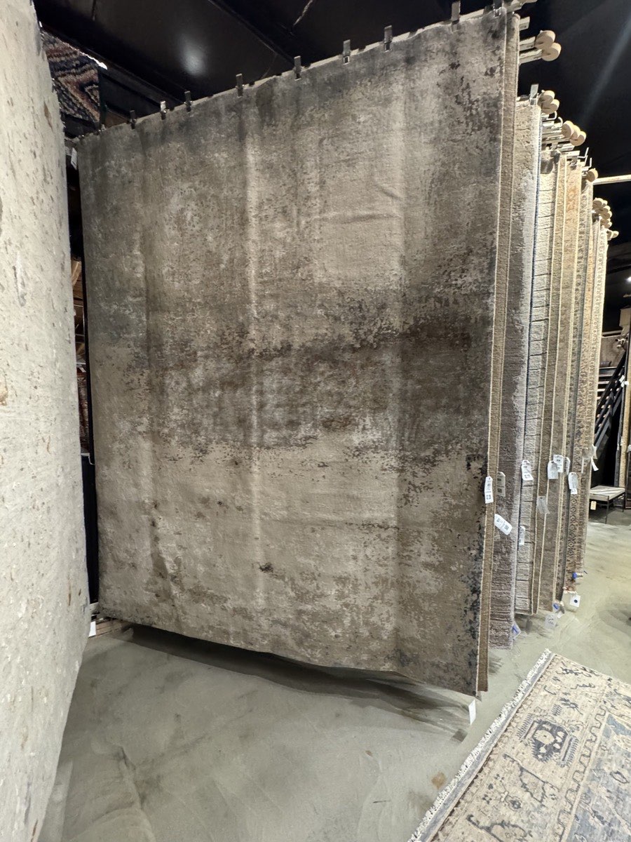 Rows of large area rugs hanging on racks in a showroom, illustrating an overwhelming number of choices