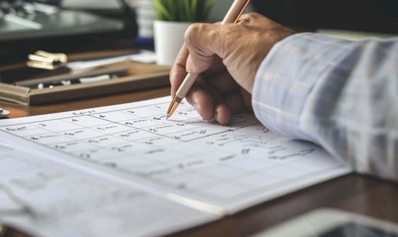Veterinarian planning the appointment schedule by hand on a paper calendar